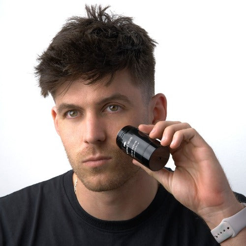 Profile of man using face serum